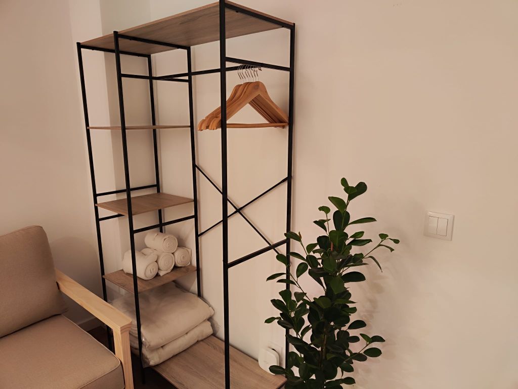 Azulejos — roupeiro aberto com cabides e planta
