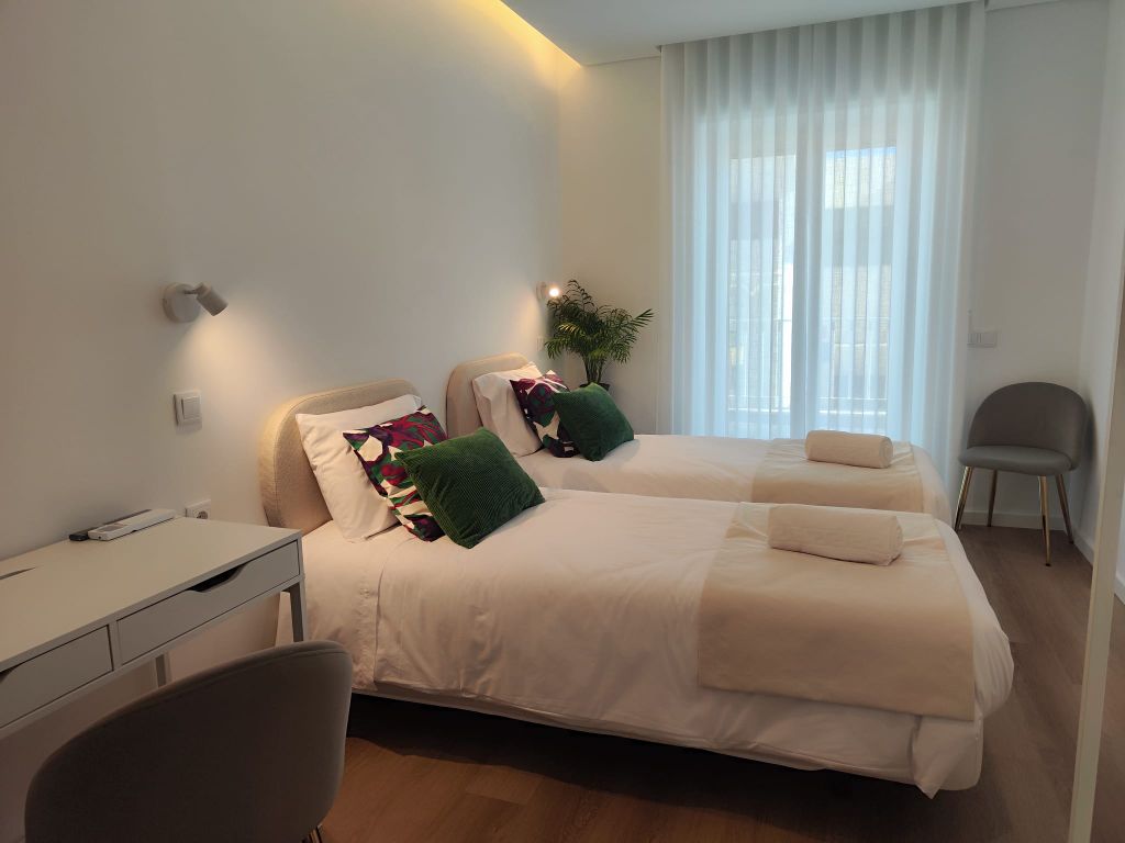 Jacarandás — quarto twin com almofadas florais