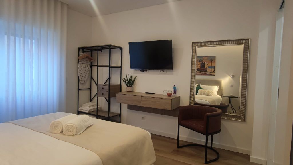 Muralhas — quarto de casal com TV e espelho